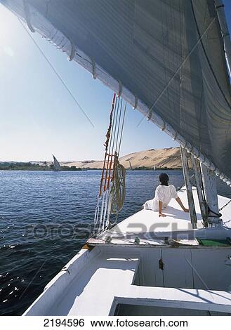 Stock Photograph - Egypt, Woman sitting on bow of felucca on River Nile; Aswan. Fotosearch
