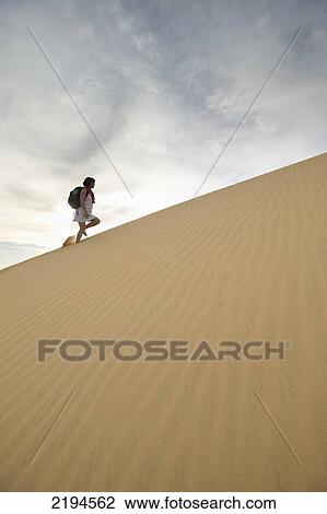 Egypt, Woman walking up sand dunes; Aswan View Large Photo Image Stock Image - Egypt, Woman walking up sand dunes; Aswan. Fotosearch