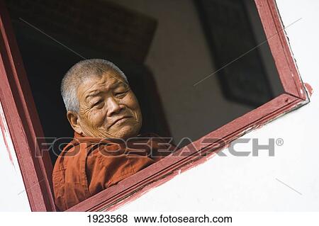 Stock Photo - Elderly Monk Sitting By Window, Luang Prabang, Laos. Fotosearch