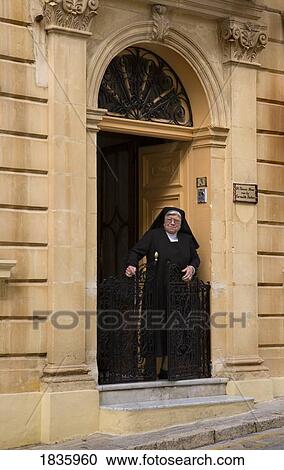 Stock Image - Elderly Nun In Exterior Doorway. Fotosearch