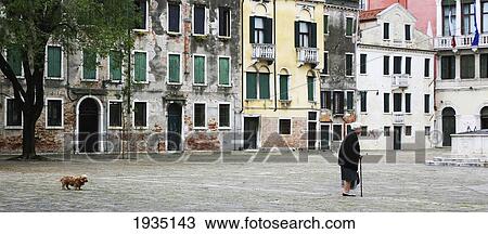 Stock Image - Elderly Woman Walking Her Dog; Venice, Italy. Fotosearch