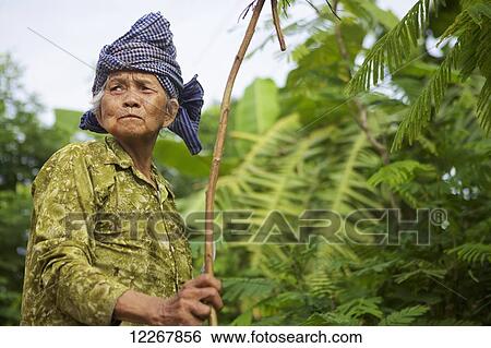 Stock Photograph - Elderly woman with a stick; Battambang, Cambodia. Fotosearch
