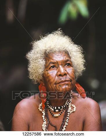 Stock Photograph - Elderly woman with tattooed face; Oro Province, Papua New Guinea. Fotosearch