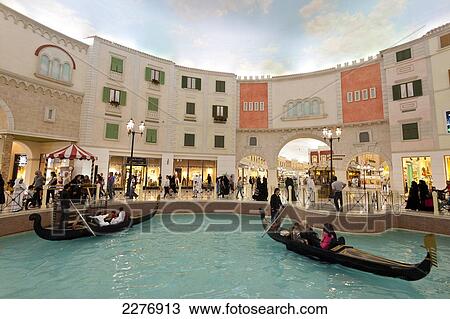 Stock Image - Electric gondolas on canal in the Villagio shopping mall; Doha, Qatar. Fotosearch