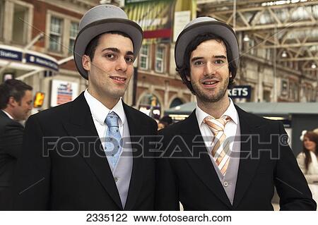 Stock Image - Elegant Men At Waterloo Station For Lady's Day At Royal Ascot; London, England, Uk. Fotosearch