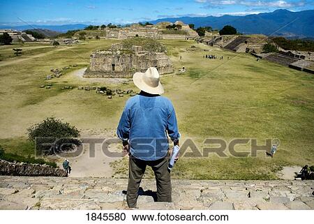 Stock Image - Elevated Rear View Of Man Watching Ancient Mayan Ruins; Mexico. Fotosearch