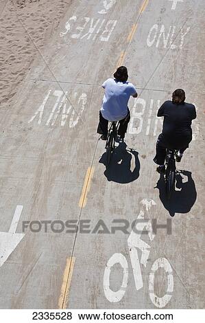 Stock Photo - Elevated View Of Two Cyclists In Bicycle Lane; California, Usa. Fotosearch