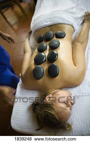 Elevated View Of Young Woman Having hot stone Therapy In Atlantis Beach Resort; Puerto Gallera, Mindoro Island, Philippines View Large Photo Image Stock Photo - Elevated View Of Young Woman Having hot stone Therapy In Atlantis Beach Resort; Puerto Gallera, Mindoro Island, Philippines. Fotosearch