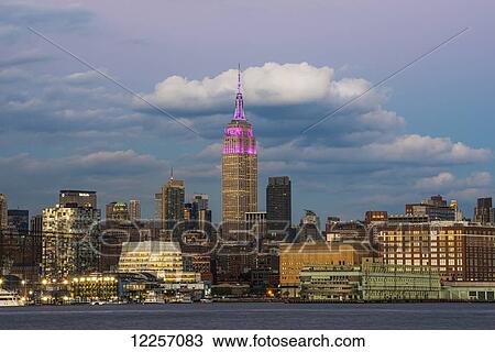 Stock Image - Empire State Building at sunset with colour honouring the Cupus Foundation of America; New York City, New York, United States of America. Fotosearch