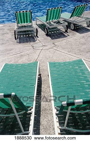Stock Image - Empty Green Sun Loungers. Fotosearch