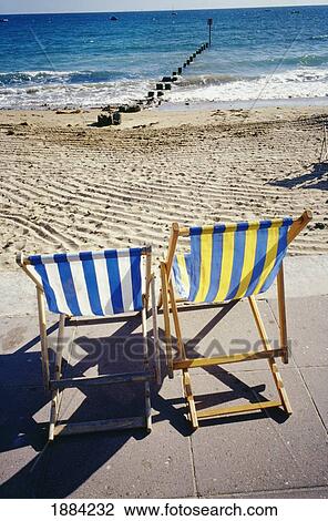 Stock Image - Empty Striped Beach Chairs On The Beach. Fotosearch