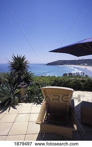 Stock Photo - Empty Sun Lounger On A Patio Overlooking The Sea. Fotosearch