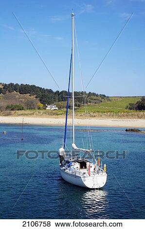 Stock Photo - England, Channel Islands, Sailing boat leaving coast; Herm. Fotosearch