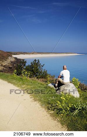 Stock Photo - England, Channel Islands, Tourist on Shell Beach; Herm. Fotosearch