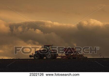 England, Northumberland, Tractor working on field under storm cloud View Large Photo Image Stock Photograph - England, Northumberland, Tractor working on field under storm cloud. Fotosearch