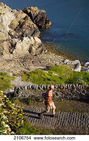 England, Saints Bay Harbour; Channel Islands, Tourist on cliff route View Large Photo Image Picture - England, Saints Bay Harbour; Channel Islands, Tourist on cliff route. Fotosearch