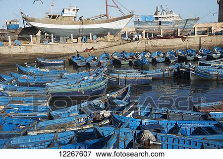 Essaouira harbour with blue boats and fishermen packing fresh catch; Essaouira, Morocco View Large Photo Image Stock Photo - Essaouira harbour with blue boats and fishermen packing fresh catch; Essaouira, Morocco. Fotosearch