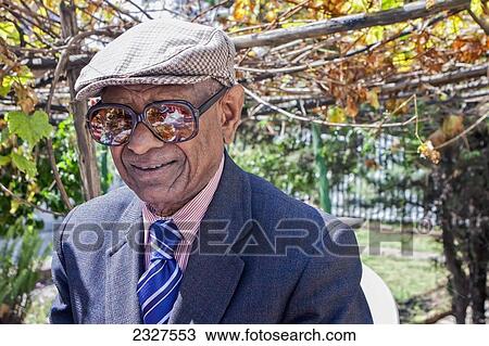 Stock Image - Ethiopia, Portrait of senior Ethiopian man wearing suit outside Taitu Hotel- oldest in city; Addis Ababa. Fotosearch