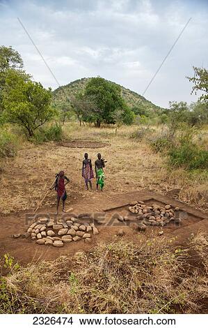 Picture - Ethiopia, South Western Ethiopia, Omo Valley, Southern Mursiland, View of three Mursi warriors on field; Dirikoro. Fotosearch