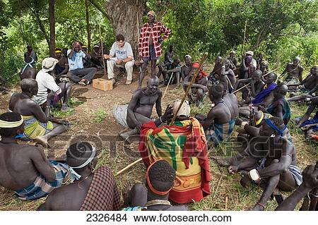 Picture - Ethiopia, South Western Ethiopia, Omo Valley, Southern Mursiland, View of archaeologist with Mursi people; Dirikoro. Fotosearch