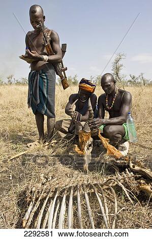 Ethiopia, Southern Nations Nationalities And Peoples' Region, South Omo, Mursi Tribal Men With Remains Of Topi Killed By Lion On Savanah; Southern Mursiland View Large Photo Image Stock Image - Ethiopia, Southern Nations Nationalities And Peoples' Region, South Omo, Mursi Tribal Men With Remains Of Topi Killed By Lion On Savanah; Southern Mursiland. Fotosearch