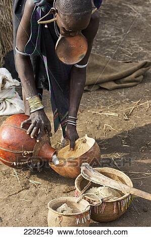 Ethiopia, Southern Nations Nationalities And Peoples' Region, South Omo, Mursiland, Mursi Tribal Woman With Large Pottery Lip-Plate (Dhebi) Cooking; Mirobe Village View Large Photo Image Stock Photo - Ethiopia, Southern Nations Nationalities And Peoples' Region, South Omo, Mursiland, Mursi Tribal Woman With Large Pottery Lip-Plate (Dhebi) Cooking; Mirobe Village. Fotosearch