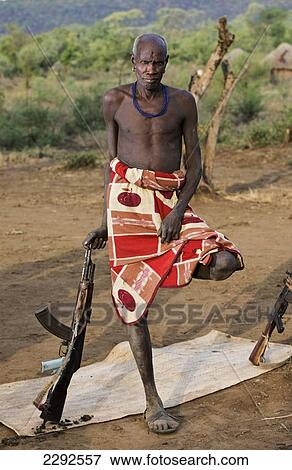 Stock Photo - Ethiopia, Southern Nations Nationalities And Peoples' Region, South Omo, Mursiland, Portrait Of Mursi Tribal Man With Gun; Maridungka Village. Fotosearch