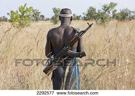 Stock Photo - Ethiopia, Southern Nations Nationalities And Peoples' Region, South Omo, Rear View Of Mursi Tribal Man With Gun On Savanah; Southern Mursiland. Fotosearch