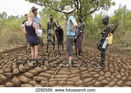 Ethiopia, Southern Nations Nationalities And Peoples' Region, South Omo, Southern Mursiland, Mursi Tribesmen And Archaeologists Next To Benna Kulugto Stone Platforms; Dirikoro View Large Photo Image Stock Photography - Ethiopia, Southern Nations Nationalities And Peoples' Region, South Omo, Southern Mursiland, Mursi Tribesmen And Archaeologists Next To Benna Kulugto Stone Platforms; Dirikoro. Fotosearch