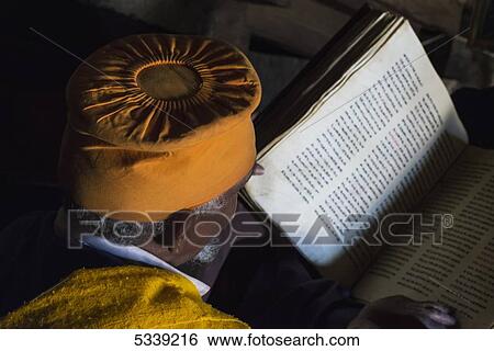 Stock Photograph - Ethiopian Orthodox Christian priest and Bible; Lalibela, Ethiopia. Fotosearch