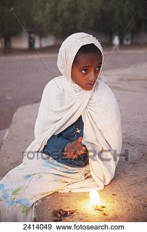 Stock Photo - Ethiopian orthodox girl at night parade of the tabot (replica of the Ark of the Covenant) around the city; Axum, Tigray region, Ethiopia. Fotosearch