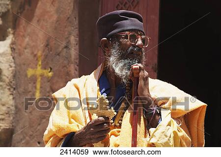 Ethiopian Orthodox priest with cross and prayer stick, Wukro Chirkos rock-cut church; Wukro, Tigray region, Ethiopia View Large Photo Image Stock Photo - Ethiopian Orthodox priest with cross and prayer stick, Wukro Chirkos rock-cut church; Wukro, Tigray region, Ethiopia. Fotosearch