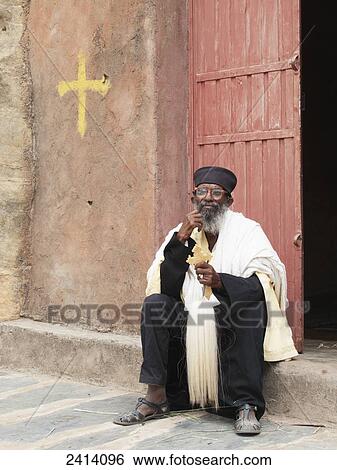 Stock Photograph - Ethiopian Orthodox priest with cross, Wukro Chirkos rock cut church; Wukro, Tigray region, Ethiopia. Fotosearch