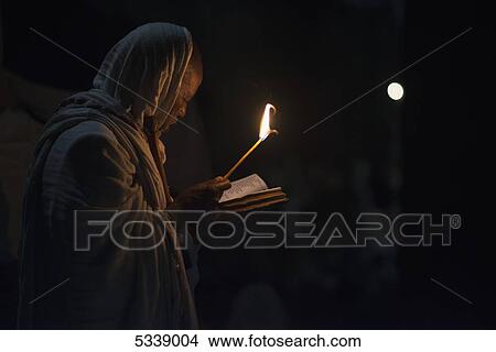 Picture - Ethiopian pilgrim reading scripture by candlelight; Ethiopia. Fotosearch