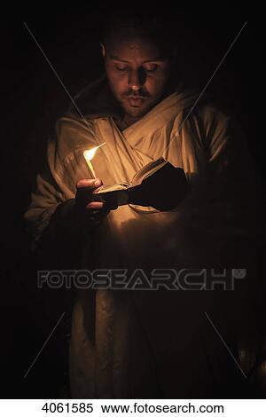 Stock Photography - Ethiopian pilgrim with Bible and candle; Lalibela, Ethiopia. Fotosearch