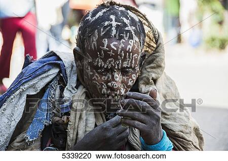 Ethiopian young man with white painted crosses and symbols all over his face and head; Lalibela, Ethiopia View Large Photo Image Stock Image - Ethiopian young man with white painted crosses and symbols all over his face and head; Lalibela, Ethiopia. Fotosearch