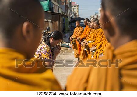 Picture - Every morning young monks go around the city blessing every shop or restaurant; Battambang, Cambodia. Fotosearch