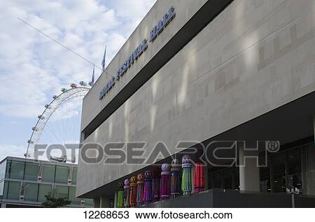 Stock Image - Exterior of the Royal Festival Hall with the London Eye in the background; London, England. Fotosearch