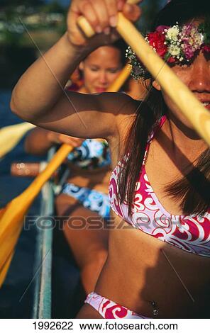 Stock Image - Extreme Closeup Angled View Of Women Paddlers In Canoe, Afternoon With Shadows.. Fotosearch