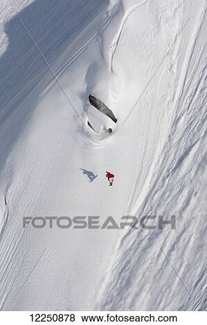 Stock Photo - Extreme snowboarding on a snow covered slope; Haines, Alaska, United States of America. Fotosearch