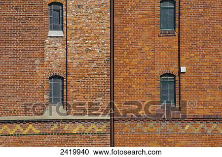 Stock Image - Facade of a brick building with windows and a patterned stripe; Hamburg, Germany. Fotosearch
