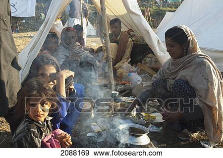 Stock Photo - Family Having Breakfast In A Relief Camp Tent After The 8 October 2005 Earthquake, Bagh, Azad Kashmir, Pakistan. Fotosearch