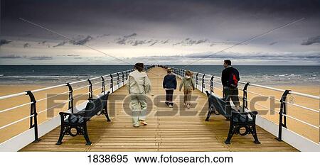 Stock Photography - Family Of Four On Pier; Saltburn By The Sea, Yorkshire, England, Uk. Fotosearch