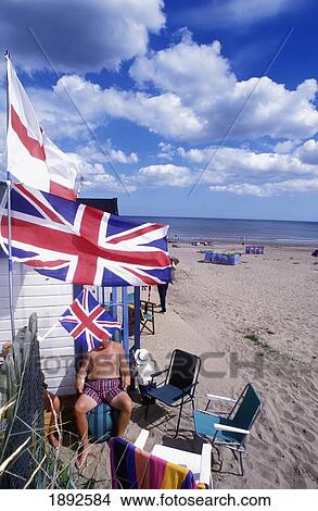 Picture - Family Outside Beach Hut With British Flags. Fotosearch