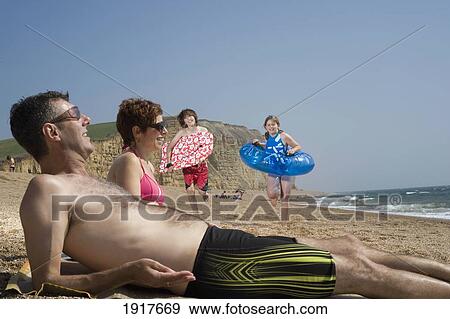 Stock Photo - Family Relaxing On Beach. Fotosearch