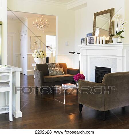 Stock Photo - Family room with brown loveseats cream walls and a fireplace; Victoria vancouver island british columbia canada. Fotosearch