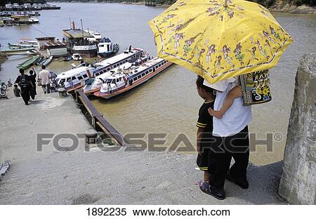 Stock Photography - Family With Umbrella Near Rejang River At A Kapit. Fotosearch