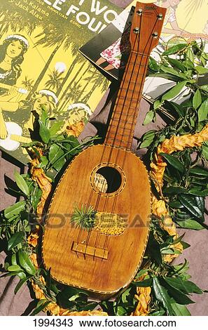 Stock Image - Famous Kamaka Ukulele With Maile And Ilima Lei, Old Song Sheets.. Fotosearch