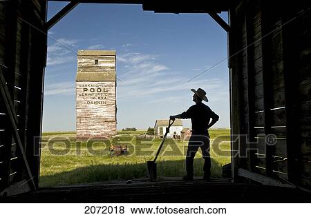 Farmer With A Shovel Looking Out At An Abandoned Grain Elevator, Dankin, Saskatchewan View Large Photo Image Stock Photo - Farmer With A Shovel Looking Out At An Abandoned Grain Elevator, Dankin, Saskatchewan. Fotosearch