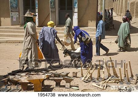 Farming implements for sale with people walking in the background at the Monday Market, Djenne, Mali View Large Photo Image Stock Photo - Farming implements for sale with people walking in the background at the Monday Market, Djenne, Mali. Fotosearch